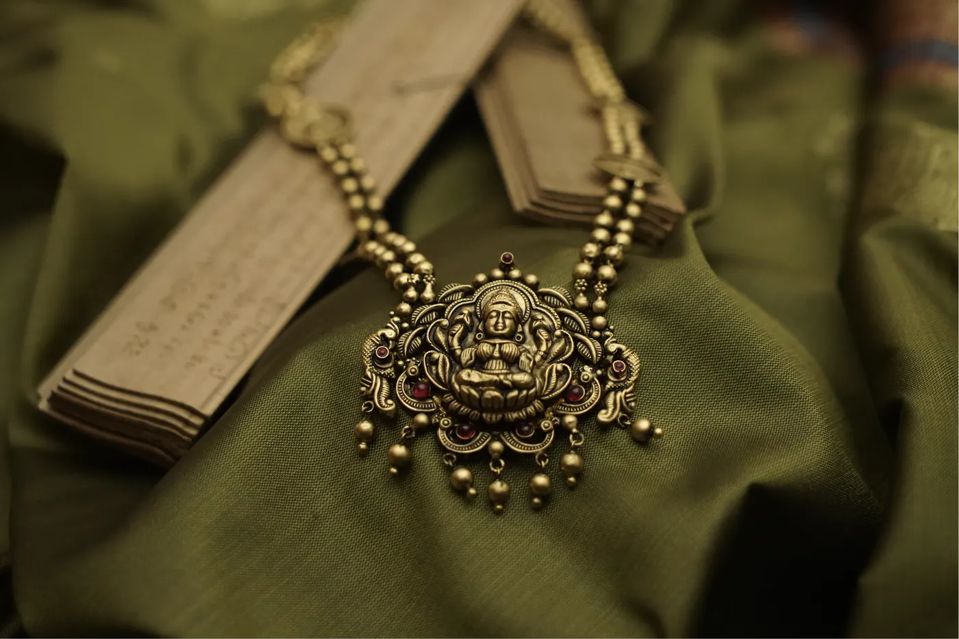 Sacred serpent pendant draped on palm leaf manuscripts