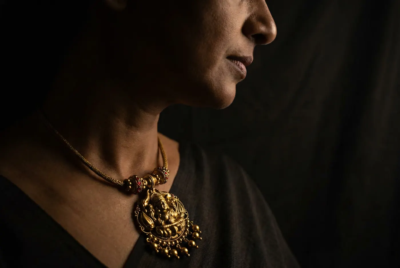 Profile silhouette wearing sacred pendant necklace