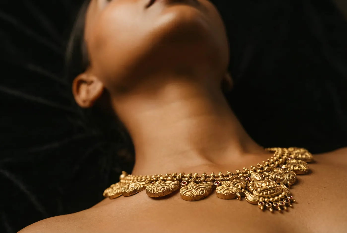 Worm's eye view of Manga Mala mango pendant draped on skin